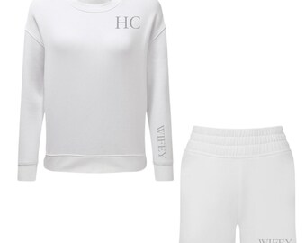 Puede incluir: Conjunto de sudadera y pantalón corto blancos. La sudadera tiene las letras "HC" en el pecho y "WIFEY" en la manga. Los pantalones cortos también tienen la palabra "WIFEY" impresa. El conjunto es de material suave.