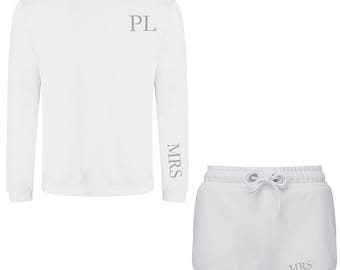 Puede incluir: Sudadera blanca de manga larga y pantalón corto blanco. La sudadera tiene "PL" bordado en la parte delantera y "MRS" bordado en la manga. Los pantalones cortos tienen "MRS" bordado en la parte posterior.