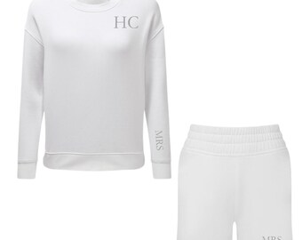 Puede incluir: Conjunto de sudadera y pantalones cortos blancos con las iniciales "HC" bordadas en la sudadera y la palabra "MRS" bordada en la manga de la sudadera y en los pantalones cortos.