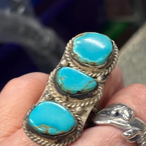 May include: A white ceramic mug with a black handle and the text "But First, Coffee" in a black, handwritten-style font. The mug is on a white surface.