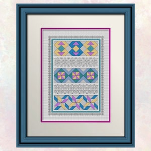 Op de afbeelding: Een ingelijst kruissteekpatroon met een geometrisch ontwerp met blauwe, gele, roze en paarse vierkanten en driehoeken. Het patroon is omgeven door een witte rand en een zwarte lijst.