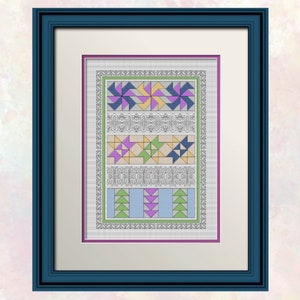 Op de afbeelding: Een ingelijst kruissteekpatroon met een kleurrijk geometrisch ontwerp met verschillende vormen, waaronder vierkanten, driehoeken en sterren. Het ontwerp is ingelijst in een donkerblauwe lijst met een witte passe-partout.