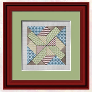 Op de afbeelding: Een ingelijst kruissteekontwerp met een kleurrijk patchwork-patroon met een stervormig ontwerp in het midden.