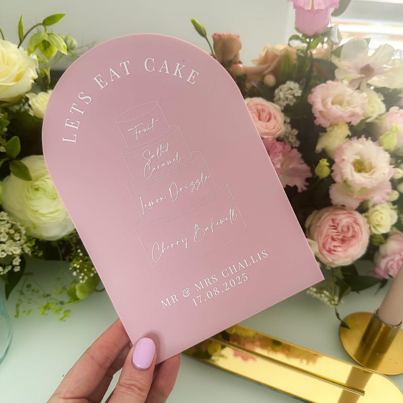 hand holding pink dome cake sign