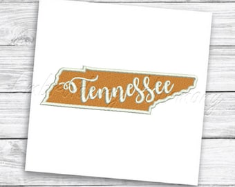 May include: An embroidered patch featuring the state of Tennessee in a rectangular shape. The patch has a tan background with the word "Tennessee" in white cursive script. The patch is outlined in white.