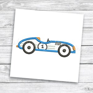 May include: Blue and white vintage race car with a number one on the side. The car has black wheels and orange accents.