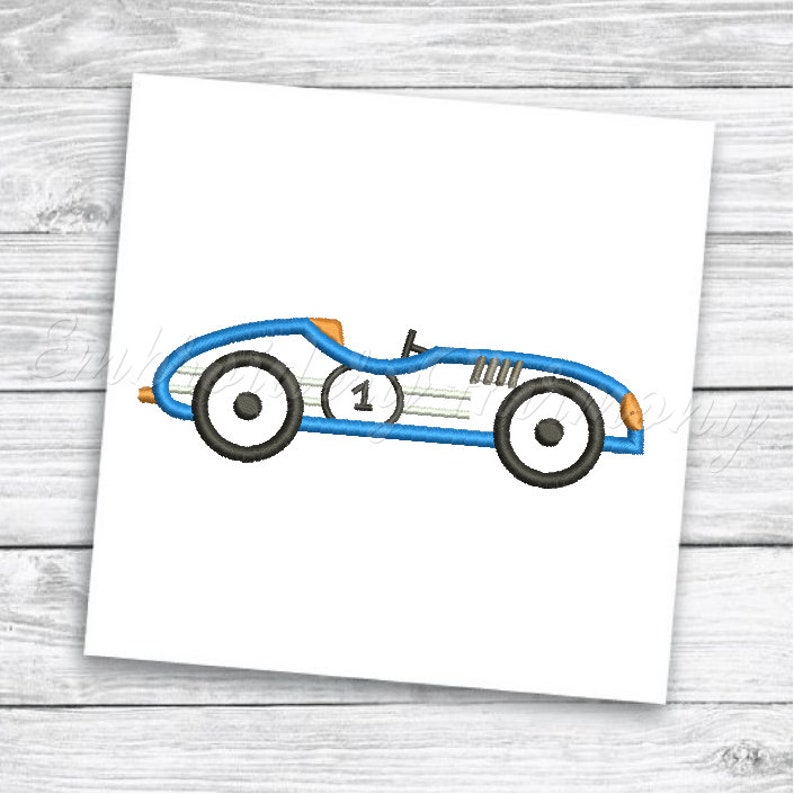 May include: Blue and white vintage race car with a number one on the side. The car has black wheels and orange accents.