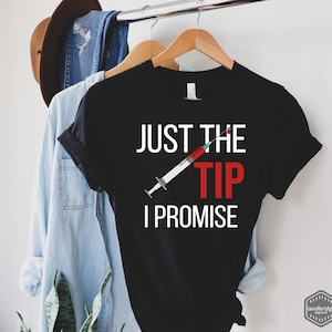 May include: Black t-shirt with white text that reads "Just the tip I promise" and a red and white syringe graphic.