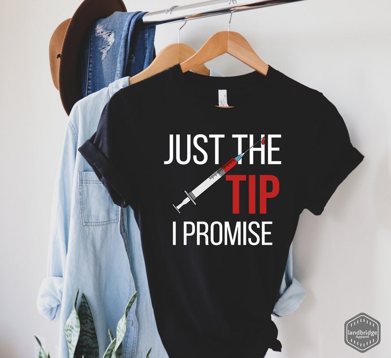 May include: Black t-shirt with white text that reads "Just the tip I promise" and a red and white syringe graphic.
