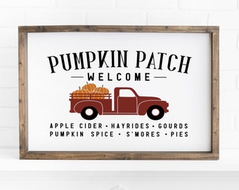 Puede incluir: Un letrero blanco con un marco de madera marrón, que presenta un camión rojo que lleva calabazas. El letrero dice "Pumpkin Patch - Welcome - Apple Cider - Hayrides - Gourds - Pumpkin Spice - S'mores - Pies".