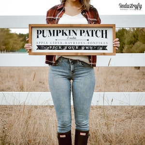 Könnte beinhalten: Ein rustikales Holzschild mit schwarzem Text, auf dem steht "Pumpkin Patch 2 miles Apple Cider - Hayrides - Bonfires 25c Pick Your Own 25c".