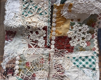 May include: A textile collage featuring a patchwork of various fabric scraps, including floral prints, green gingham, and solid mustard yellow. The piece is heavily embellished with white lace, crochet motifs, small buttons, and a butterfly applique.