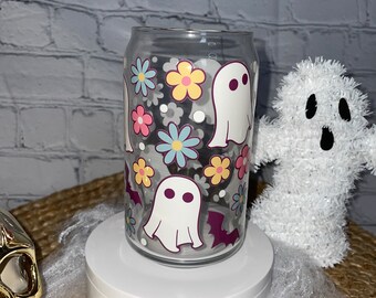 Peut inclure: Un gobelet en verre transparent sur le thème d'Halloween. Le gobelet est décoré de fantômes blancs, de chauves-souris et de fleurs colorées.