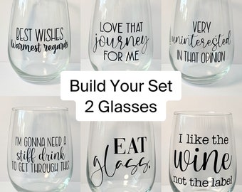 Peut inclure: Ensemble de six verres à vin en verre transparent avec différentes citations humoristiques imprimées dessus. Les citations incluent "Meilleurs vœux, sincères salutations", "J'adore ce voyage pour moi", "Très désintéressé par cette opinion", "J'ai besoin d'un verre pour passer à travers ça", "Manger du verre", et "J'aime le vin, pas l'étiquette".