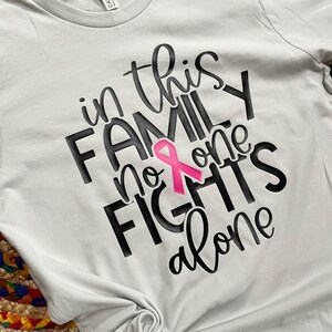 In questa famiglia nessuno combatte da solo - Maglietta per la consapevolezza del cancro al seno