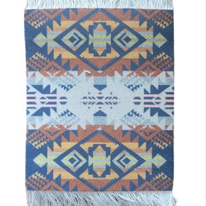 May include: A small, rectangular rug with a geometric pattern in shades of blue, orange, yellow, and white. The rug has a fringe border.