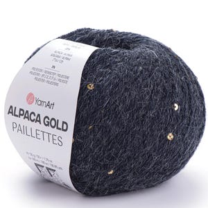May include: A ball of dark gray Alpaca Gold yarn with gold sequins. The label reads "YarnArt ALPACA GOLD PAILLETTES". The yarn is a soft, textured material, perfect for knitting or crocheting projects. The ball weighs 50g / 1.76 oz.