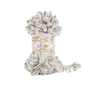 Peut inclure: Une pelote de fil bouclé blanc et noir, marque Alize Puffy, pour le tricot ou le crochet.