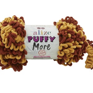 May include: A skein of Alize Puffy More yarn in a brown and gold colour combination. The yarn is a bulky weight and is made of 100% microfiber. The label reads "Alize Puffy More" and "Patented".