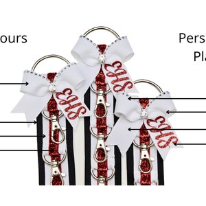 May include: Three white and red striped keychains with a white bow and a red glitter 'EHS' on each. The bow has a rhinestone in the center. The keychains are shown with different personalization placement options: left loop, right loop, left tail, and right tail.