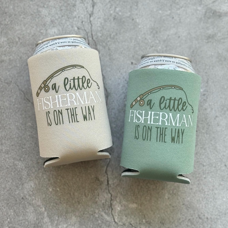 May include: Two beige and green can coolers with a fishing rod and the text "a little fisherman is on the way".