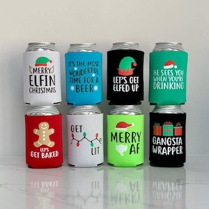 May include: Eight different Christmas-themed can coolers with various designs and sayings. The designs include a gingerbread man, a Christmas tree, a Santa hat, and an elf. The sayings include "Merry Elfin Christmas", "It's the most wonderful time for a beer", "Let's get elfed up", "He sees you when you're drinking", "Let's get baked", "Get lit", "Merry AF", and "Gangsta Wrapper".