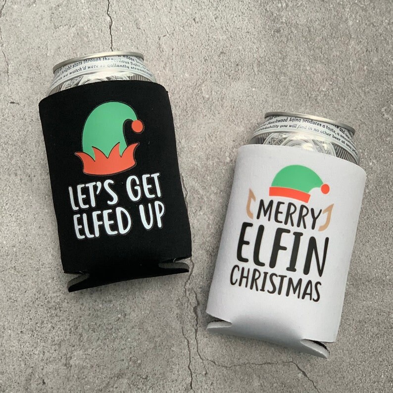 May include: Two black and white beverage insulators with a Christmas elf design. One insulator says "Let's Get Elfed Up" and the other says "Merry Elfin Christmas".