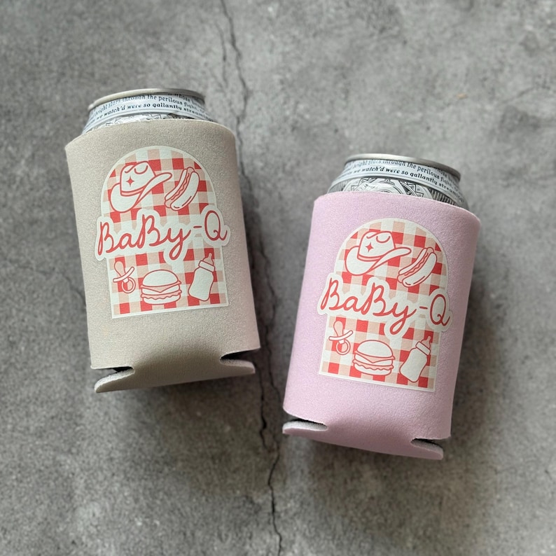 May include: Two can coolers, one tan and one pink, each holding a can. The coolers have a "Baby-Q" design with a cowboy hat, hot dog, baby bottle, and burger on a red and white checkered background.