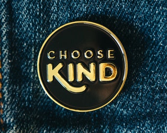 May include: A black and gold enamel pin with the words "Choose Kind" in gold lettering.