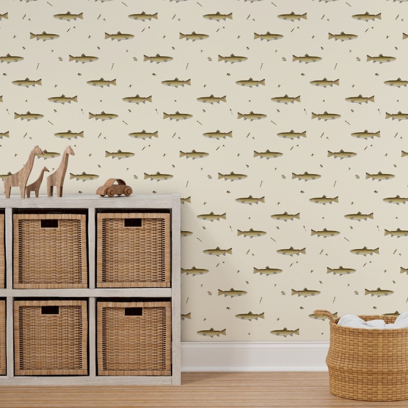 May include: A cream-colored wallpaper featuring a repeating pattern of brown fish, small black insects, and thin brown lines. The scene includes a white shelf with woven baskets and wooden animal toys, creating a playful, nature-inspired theme.