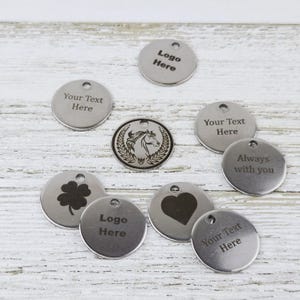 May include: Nine silver round metal tags with various designs and text. The tags include a horse head, a clover, a heart, and the text "Logo Here", "Your Text Here", and "Always with you".