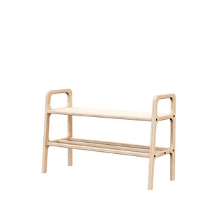 May include: A light-coloured wooden shoe rack with two shelves and a handle-like design on each side. The rack has a simple, modern design and is made of light-coloured wood.