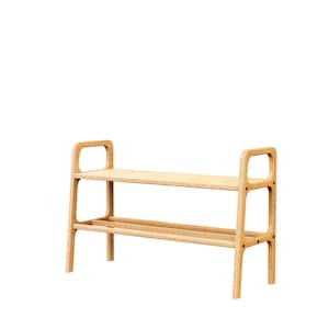 May include: A light-coloured wooden shoe rack with two shelves. The top shelf is a flat surface, and the bottom shelf has two horizontal bars. The rack has a rectangular frame with rounded handles on each side.
