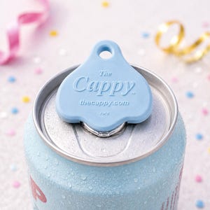 K&ouml;nnte beinhalten: Eine hellblaue Getr&auml;nkedose mit einem passenden blauen "Cappy" Dosenaufsatz. Auf dem Dosenaufsatz steht "The Cappy" und "thecappy.com". Die Dose hat Kondenswasser.