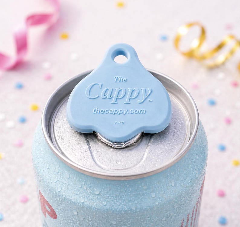 K&ouml;nnte beinhalten: Eine hellblaue Getr&auml;nkedose mit einem passenden blauen "Cappy" Dosenaufsatz. Auf dem Dosenaufsatz steht "The Cappy" und "thecappy.com". Die Dose hat Kondenswasser.