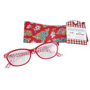 May include: Red reading glasses with a floral pattern on the arms and a matching soft case. The glasses have a +1.50 magnification. The case is red with a floral pattern and a gingham tag that reads "Stitchy Readers with Soft Case."