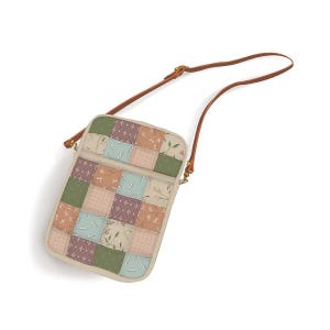 May include: A patchwork crossbody bag with a brown leather strap. The bag features a rectangular design with a variety of square patches in shades of green, beige, and peach, with floral and bird patterns. The strap is adjustable.