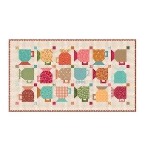May include: A rectangular quilt featuring a repeating pattern of stylized mugs in various floral and geometric prints. The mugs are arranged in a grid on a cream background with small brown dots, finished with a scalloped red and brown border.