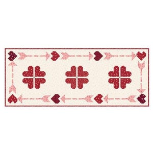 May include: A rectangular quilt with a cream-colored background and a repeating pattern of red hearts and arrows. The border features arrows and hearts, with three large heart-shaped designs in the center. The quilt is a charming, handmade item.