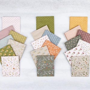 May include: An overhead shot displays three sets of fabric squares in various colors and patterns. Each set includes a larger square surrounded by smaller, coordinating pieces. The fabrics feature floral, dotted, and geometric designs, in shades of green, pink, and yellow.