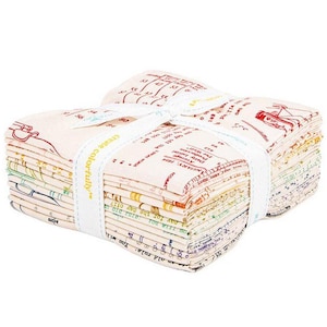 May include: A stack of fabric squares tied with a white ribbon. The fabric has a cream background with colorful illustrations and text. The ribbon is printed with the words "create colorfully".