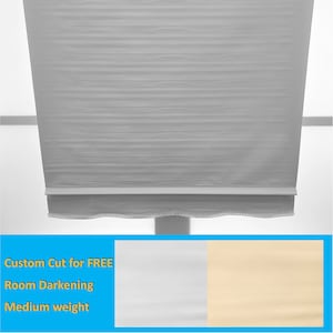 May include: A white room darkening roller shade with a medium weight fabric. The shade is custom cut for free. The fabric is available in white or beige.