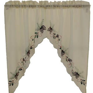 May include: A pair of off-white sheer kitchen valances with a scalloped edge. The valances feature an embroidered design of pine cones, holly, and red berries.