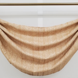 May include: A beige valance with a subtle pattern hangs from a gold curtain rod. The valance is gathered in the center, creating a soft, curved shape.