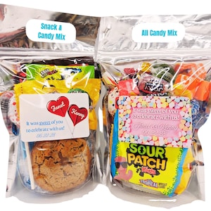 May include: Two clear cellophane bags filled with candy and snacks. One bag is labeled "Snack & Candy Mix" and contains a cookie and candy. The other bag, labeled "All Candy Mix", is filled with various candies. Both bags have personalized labels.
