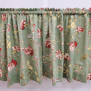 May include: A green valance with a floral pattern featuring red, white, and yellow flowers. The valance has a gathered top and a straight bottom.