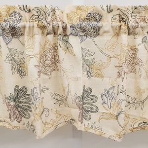 May include: Cream-colored valance with a repeating floral pattern in shades of brown, gold, and gray. The fabric is gathered at the top and has a scalloped bottom edge. A decorative window treatment.