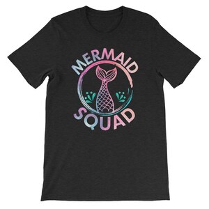 May include: A black t-shirt with a watercolor-style graphic of a mermaid tail inside a circle. The text "Mermaid Squad" is written around the circle.