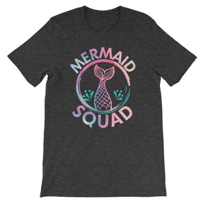 May include: A dark heather grey t-shirt with a graphic of a mermaid tail inside a circle with the text "Mermaid Squad".