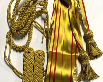 May include: A set of gold military uniform accessories, including a braided cord, a sash with red stripes, and two gold braid shoulder boards.